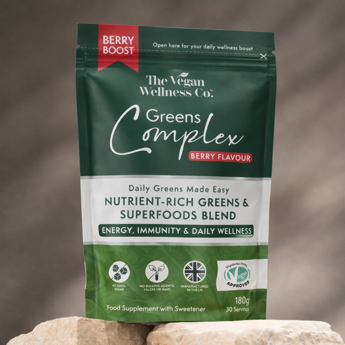 Package of The Vegan Wellness Co. Greens Complex with berry flavor on a neutral background